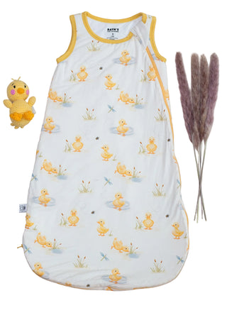 Baby sleeping bag with duck pattern on a beige background